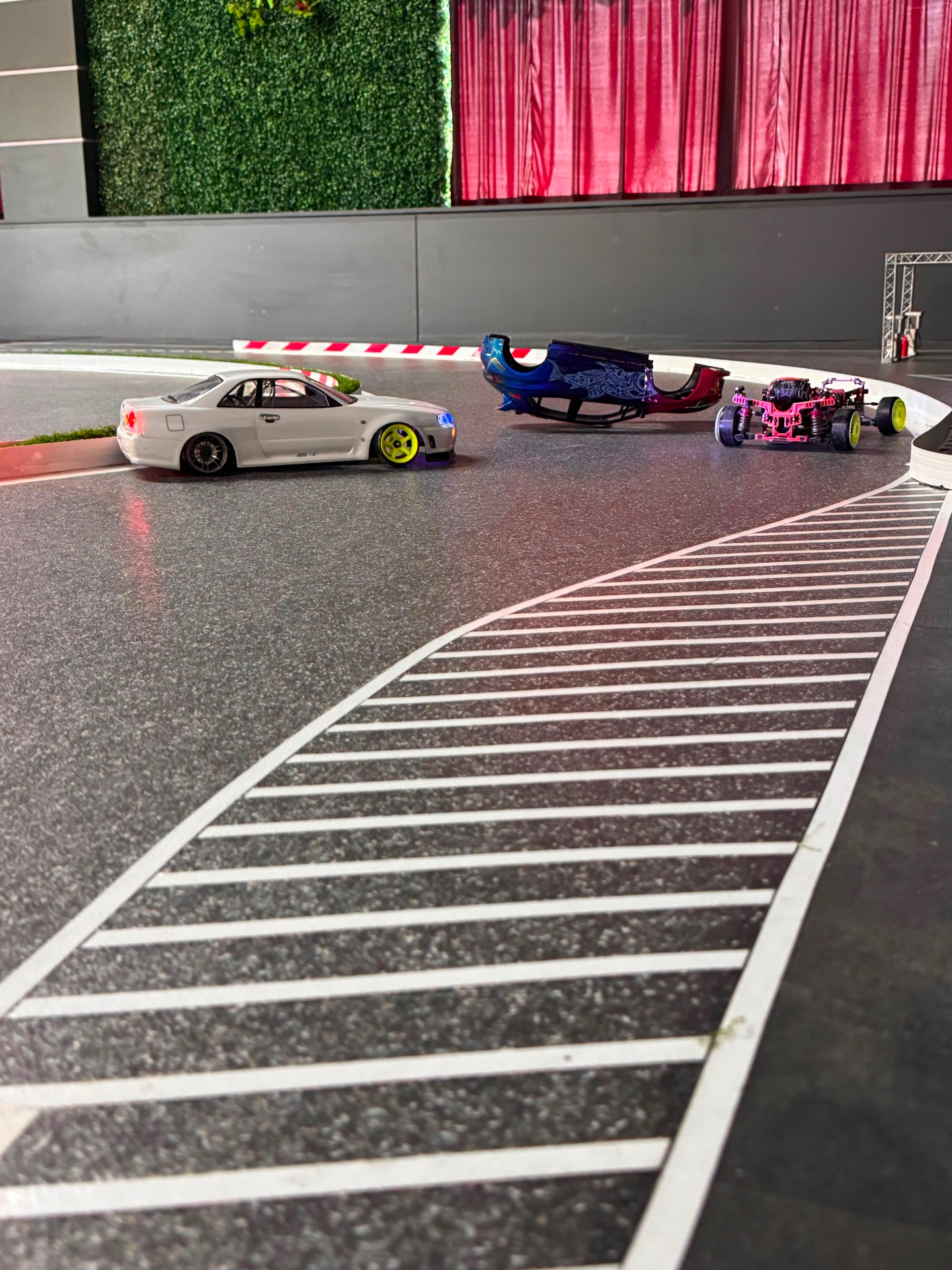 RC drift cars on a track corner with curbs
